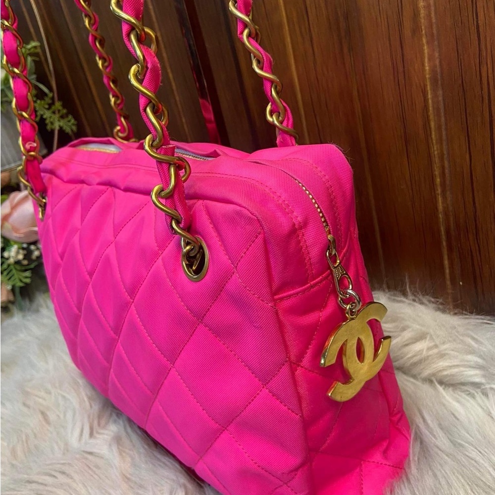 Chanel hot pink camera bag with gold hardware.